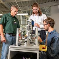 Students examining equipment with instructor